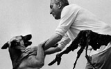 Aim Maeght e il suo cane Asco alle spalle del Cane di Giacometti il giorno dell'inaugurazione della Fondazione Marguerite e Aim Maeght, 28 luglio 1964 | Archives Maeght,  foto Jean Mounicq /ANA